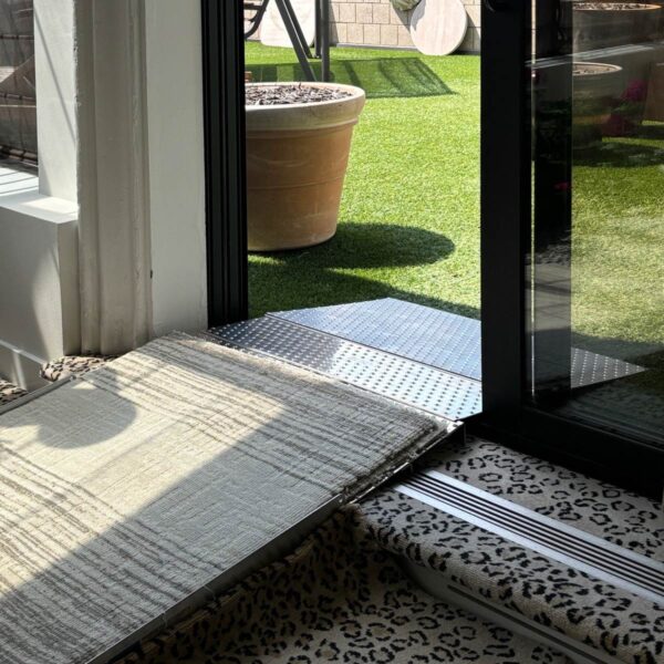 Sliding Door Threshold Ramp provides wheelchair access to exterior space.