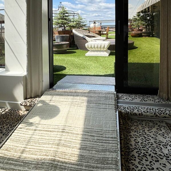 Sliding Door Threshold Ramp provides wheelchair access to exterior space.